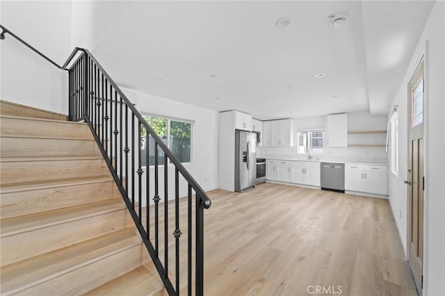 18656 Runnymede St, Reseda, CA 91335 - kitchen with appliances with stainless steel finishes, white cabinetry, light wood-style flooring, open shelves, and light countertops