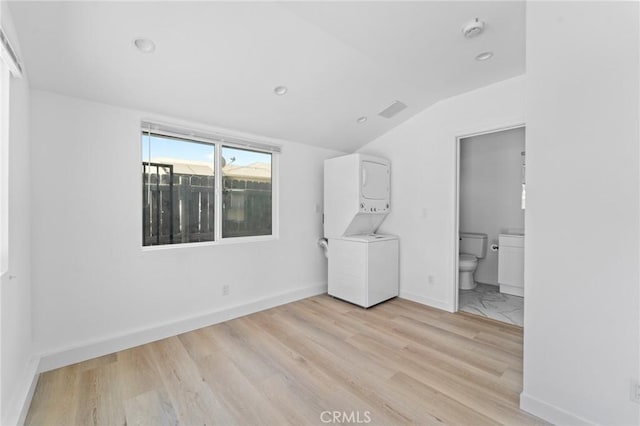 18656 Runnymede St, Reseda, CA 91335 - empty room featuring stacked washing machine and dryer, lofted ceiling, light wood-type flooring, a smoke detector, and recessed lighting