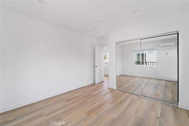 18656 Runnymede St, Reseda, CA 91335 - unfurnished bedroom featuring an AC wall unit, light wood-type flooring, and a closet
