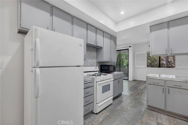 13331 Moorpark St Unit 206, Sherman Oaks, CA 91423 - kitchen featuring white appliances, gray cabinets, decorative backsplash, light countertops, and light wood-style floors