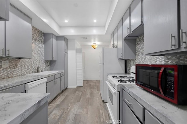 13331 Moorpark St Unit 206, Sherman Oaks, CA 91423 - kitchen with white appliances, gray cabinetry, light wood finished floors, a raised ceiling, and light countertops