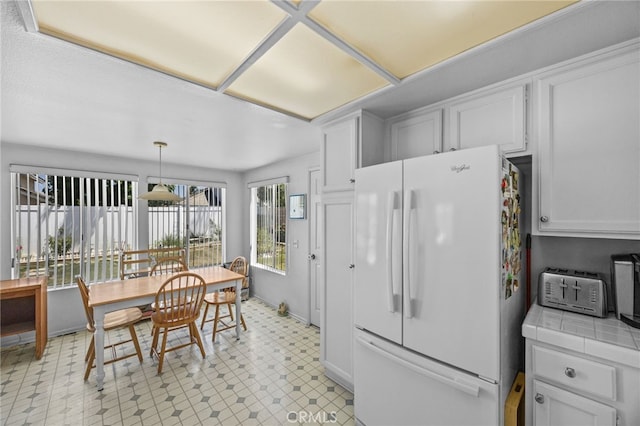 3681 Foxplain Rd, Corona, CA 92882 - kitchen featuring freestanding refrigerator, tile counters, white cabinets, and light floors