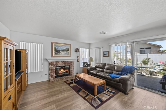 3681 Foxplain Rd, Corona, CA 92882 - living area with wood finished floors, a textured ceiling, and a fireplace