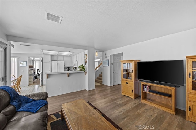 3681 Foxplain Rd, Corona, CA 92882 - living area featuring dark wood finished floors, stairs, and a textured ceiling