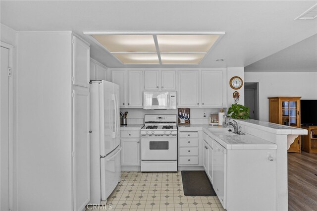 3681 Foxplain Rd, Corona, CA 92882 - kitchen with white appliances, a peninsula, light flooring, and white cabinets