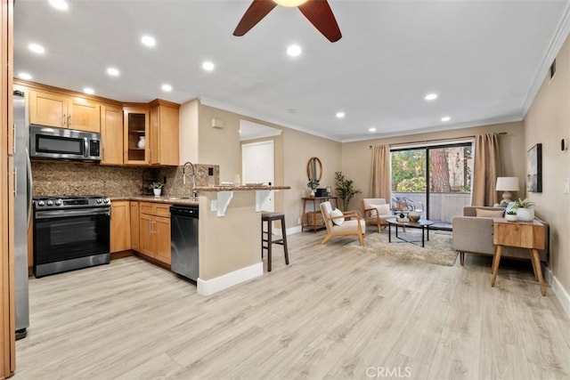 2421473 El Pilar, Laguna Niguel, CA 92677 - kitchen with stainless steel appliances, open floor plan, a peninsula, a kitchen bar, and ornamental molding