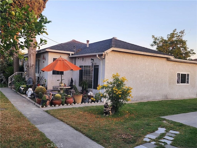 12138 Magnolia St, El Monte, CA 91732 - view of home's exterior featuring stucco siding, a yard, a shingled roof, and a patio area