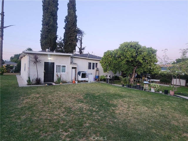 12138 Magnolia St, El Monte, CA 91732 - rear view of property featuring stucco siding and a yard