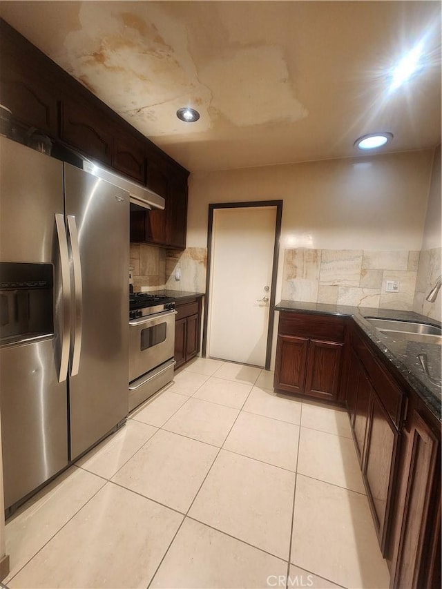 12138 Magnolia St, El Monte, CA 91732 - kitchen with appliances with stainless steel finishes, decorative backsplash, dark stone counters, light tile patterned flooring, and dark brown cabinetry