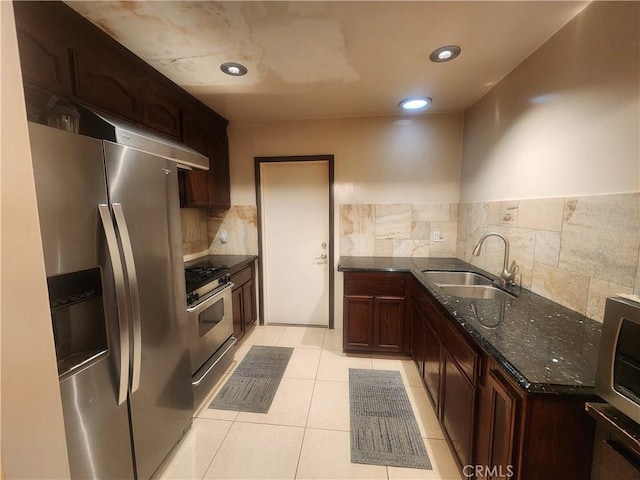 12138 Magnolia St, El Monte, CA 91732 - kitchen with appliances with stainless steel finishes, dark stone countertops, decorative backsplash, light tile patterned floors, and recessed lighting