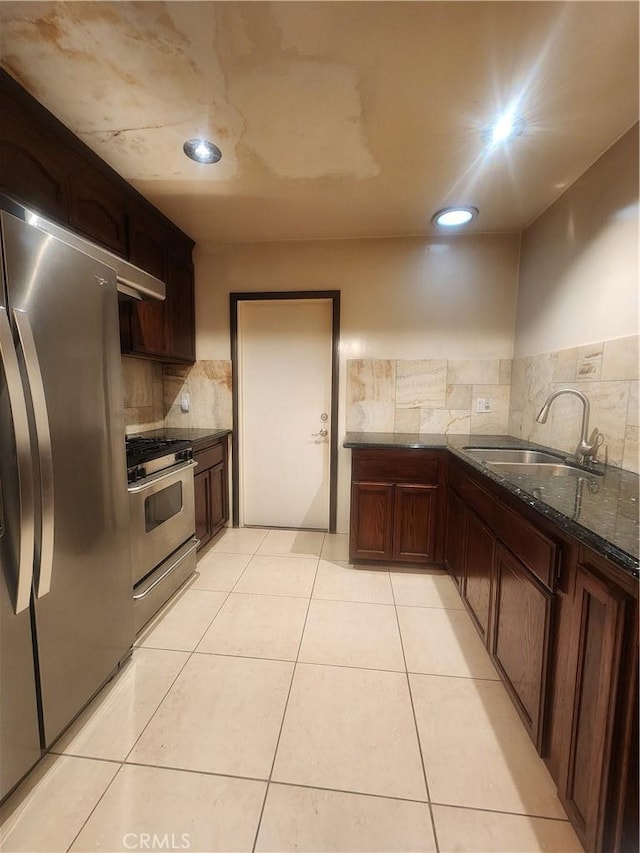 12138 Magnolia St, El Monte, CA 91732 - kitchen with stainless steel appliances, backsplash, dark stone countertops, light tile patterned floors, and recessed lighting