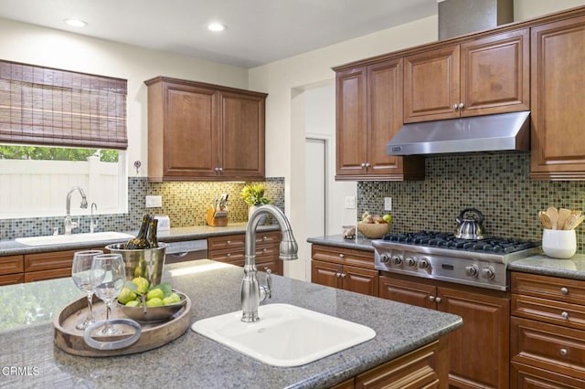 5000 Terramar Way, Oxnard, CA 93035 - kitchen with stainless steel gas stovetop, under cabinet range hood, backsplash, brown cabinets, and recessed lighting