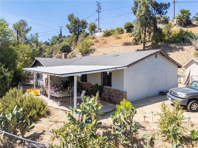138 Banbridge Ave, La Puente, CA 91744 - view of front of house featuring stucco siding, a patio, a shingled roof, and brick siding