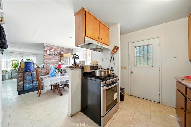 138 Banbridge Ave, La Puente, CA 91744 - kitchen featuring stainless steel gas stove, under cabinet range hood, brown cabinetry, light tile patterned floors, and light countertops