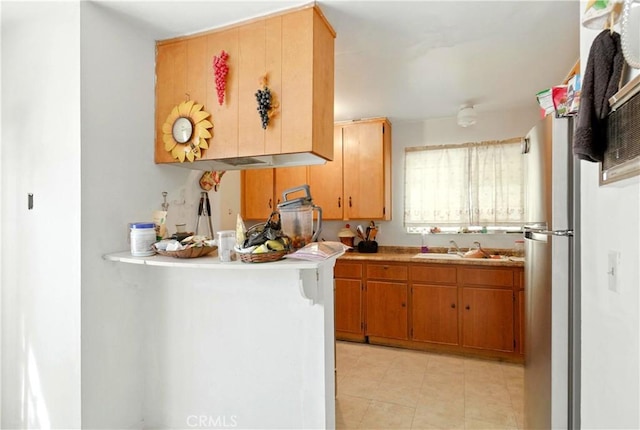 138 Banbridge Ave, La Puente, CA 91744 - kitchen featuring light countertops, light tile patterned floors, freestanding refrigerator, and brown cabinets