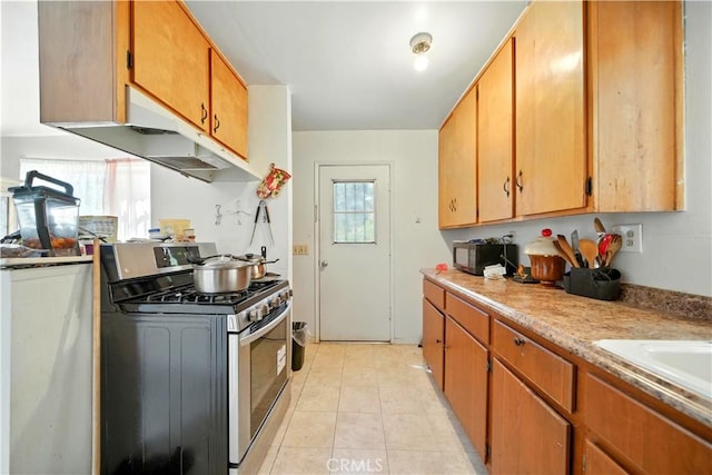 138 Banbridge Ave, La Puente, CA 91744 - kitchen featuring stainless steel gas range, light countertops, light tile patterned floors, and brown cabinets