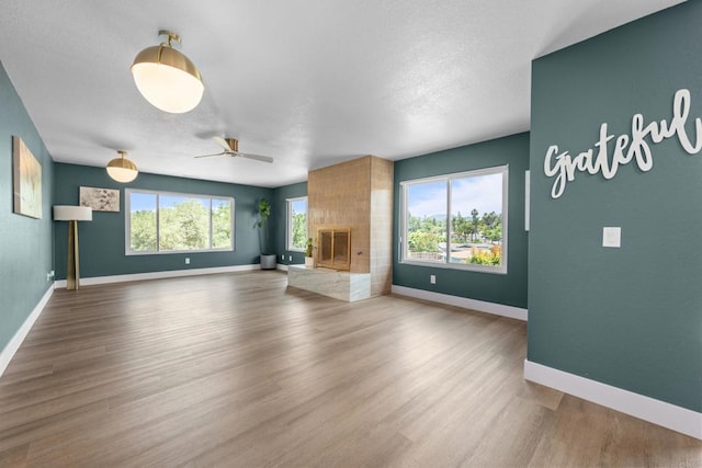 1026 Eucalyptus Ave, Vista, CA 92084 - unfurnished living room featuring a ceiling fan, wood finished floors, and a large fireplace
