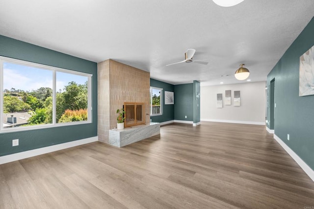 1026 Eucalyptus Ave, Vista, CA 92084 - unfurnished living room with wood finished floors, a ceiling fan, and a fireplace