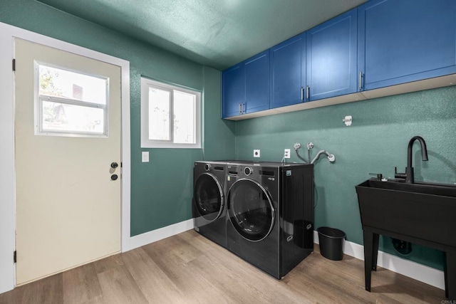 1026 Eucalyptus Ave, Vista, CA 92084 - laundry area featuring cabinet space, light wood-style floors, and independent washer and dryer
