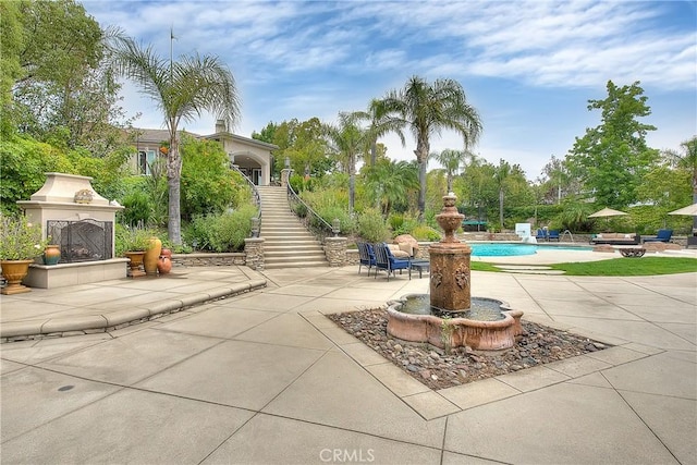 6236 Ashton Pl, Rancho Cucamonga, CA 91739 - view of patio with stairway, exterior fireplace, and an outdoor pool
