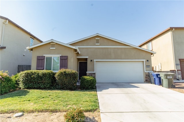 635 Pegasus Dr, Merced, CA 95348 - view of front of home with stucco siding, an attached garage, driveway, stone siding, and a front lawn