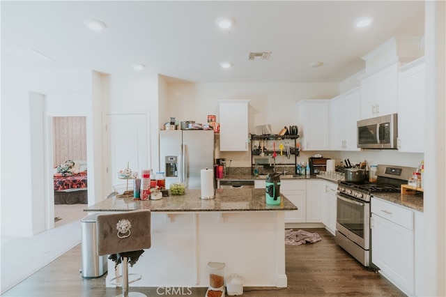 635 Pegasus Dr, Merced, CA 95348 - kitchen with appliances with stainless steel finishes, a center island, white cabinetry, stone counters, and recessed lighting