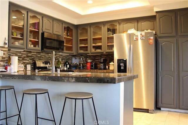 1848 Cascadian Way, San Jacinto, CA 92583 - kitchen featuring appliances with stainless steel finishes, a peninsula, glass insert cabinets, tasteful backsplash, and a breakfast bar area