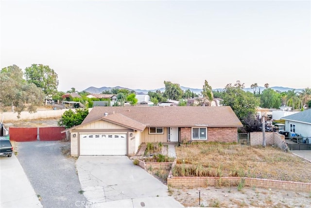 11220 Puente Way, Jurupa Valley, CA 91752 - ranch-style home featuring concrete driveway, an attached garage, a residential view, and a mountain view