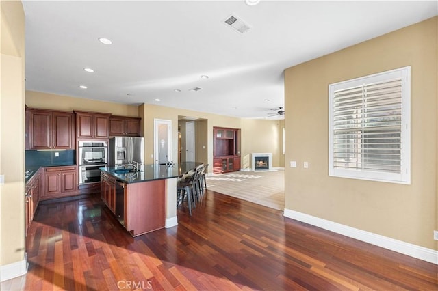 37351 Paintbrush Dr, Palmdale, CA 93551 - kitchen with dark countertops, dark wood-style floors, appliances with stainless steel finishes, a kitchen breakfast bar, and recessed lighting