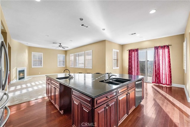 37351 Paintbrush Dr, Palmdale, CA 93551 - kitchen with stainless steel appliances, an island with sink, dark countertops, dark wood-style flooring, and recessed lighting