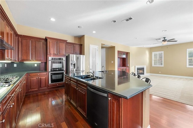 37351 Paintbrush Dr, Palmdale, CA 93551 - kitchen featuring appliances with stainless steel finishes, dark countertops, dark wood-type flooring, open floor plan, and recessed lighting