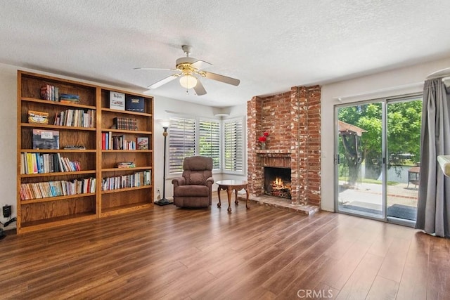 42724 Santa Suzanne Pl, Temecula, CA 92592 - sitting room featuring a textured ceiling, a ceiling fan, wood finished floors, healthy amount of natural light, and a fireplace