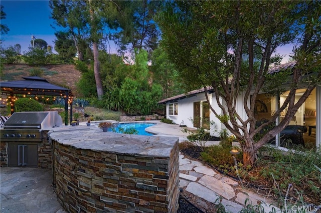 170 Buckthorn Dr, Brea, CA 92823 - patio terrace at dusk featuring exterior kitchen, a patio, an outdoor pool, and a gazebo