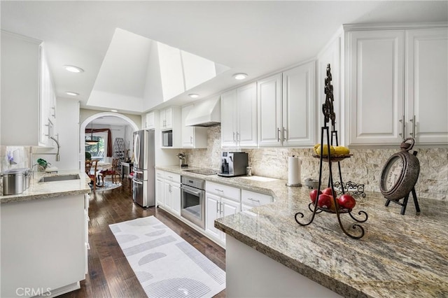 170 Buckthorn Dr, Brea, CA 92823 - kitchen with black appliances, custom range hood, arched walkways, white cabinetry, and backsplash