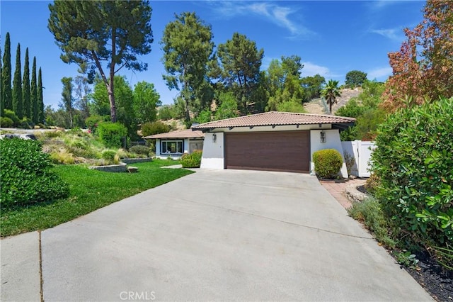 170 Buckthorn Dr, Brea, CA 92823 - view of front facade with stucco siding, a garage, driveway, and view of wooded area
