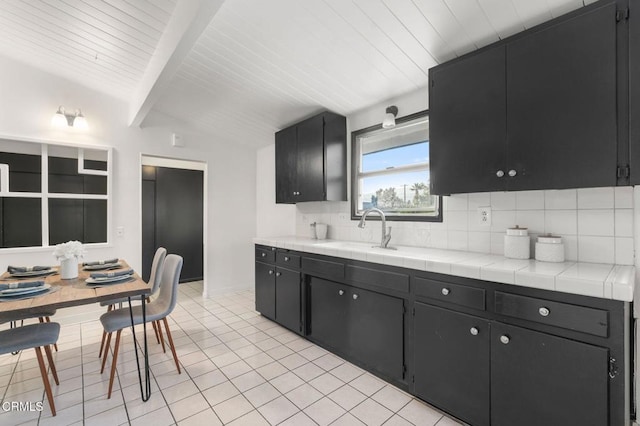 17002 E Nubia St, Covina, CA 91722 - kitchen with dark cabinetry, decorative backsplash, light tile patterned floors, and a wood ceiling with exposed beams
