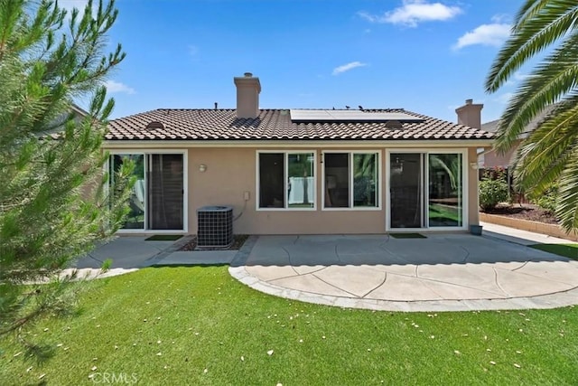 27185 Buffalo Trl, Corona, CA 92883 - back of property featuring stucco siding, solar panels, a tile roof, a lawn, and a patio