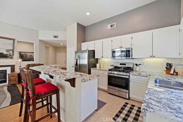 27185 Buffalo Trl, Corona, CA 92883 - kitchen with stainless steel appliances, tasteful backsplash, white cabinetry, and recessed lighting