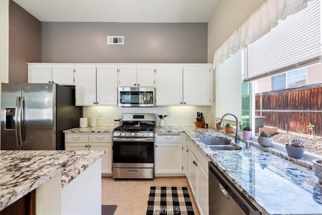 27185 Buffalo Trl, Corona, CA 92883 - kitchen featuring appliances with stainless steel finishes, backsplash, light stone counters, and white cabinets