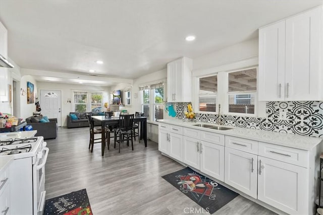 2838 N G St, San Bernardino, CA 92405 - kitchen featuring white range with gas stovetop, open floor plan, light countertops, decorative backsplash, and recessed lighting