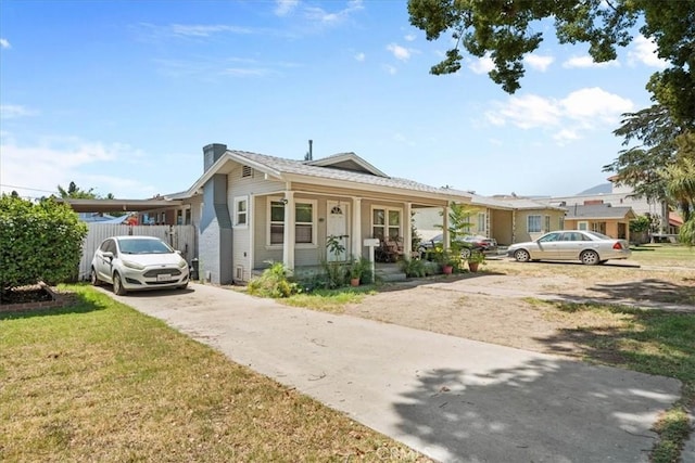 2838 N G St, San Bernardino, CA 92405 - bungalow-style house featuring a chimney, driveway, covered porch, and a front lawn