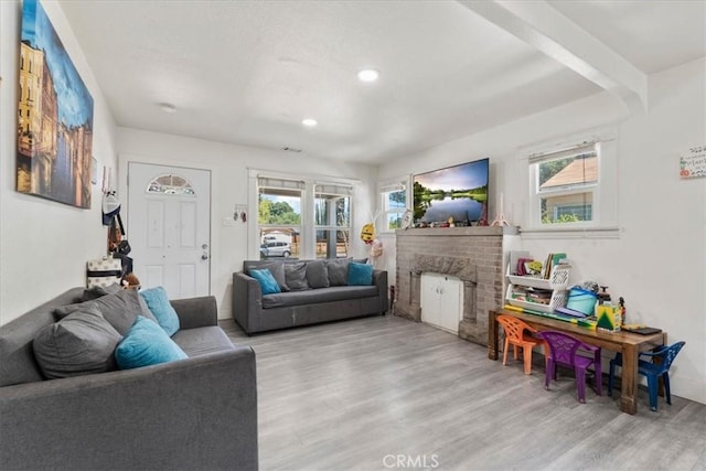 2838 N G St, San Bernardino, CA 92405 - living room featuring wood finished floors, healthy amount of natural light, a brick fireplace, and recessed lighting