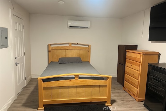 2838 N G St, San Bernardino, CA 92405 - bedroom with an AC wall unit, light wood finished floors, and electric panel
