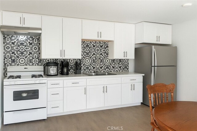 2838 N G St, San Bernardino, CA 92405 - kitchen featuring white range with gas cooktop, freestanding refrigerator, under cabinet range hood, wood finished floors, and white cabinetry