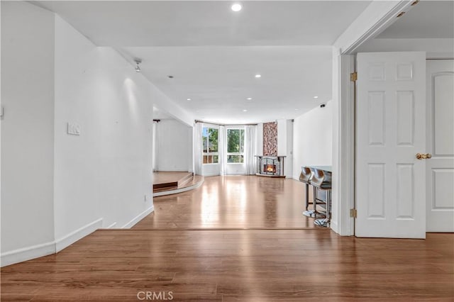 5333 Zelzah Ave Unit 203, Encino, CA 91316 - unfurnished living room with recessed lighting, wood finished floors, and a warm lit fireplace