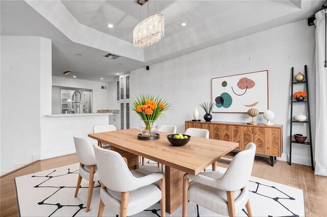 5333 Zelzah Ave Unit 203, Encino, CA 91316 - dining room featuring a raised ceiling, a chandelier, light wood-type flooring, and recessed lighting