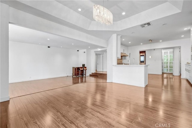 5333 Zelzah Ave Unit 203, Encino, CA 91316 - unfurnished living room with recessed lighting, wood finished floors, a chandelier, and a tray ceiling