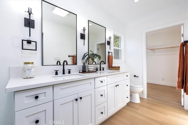 5447 Columbus Ave, Sherman Oaks, CA 91411 - full bathroom with double vanity, wood finished floors, and a walk in closet