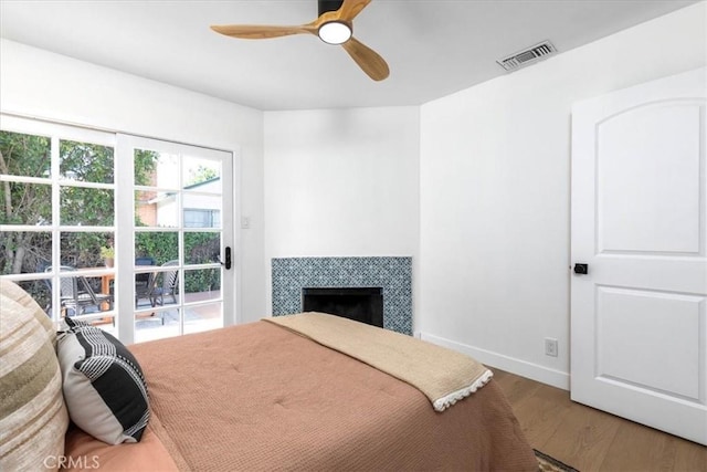 5447 Columbus Ave, Sherman Oaks, CA 91411 - bedroom featuring wood finished floors, a tiled fireplace, and ceiling fan