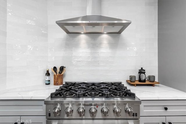 5447 Columbus Ave, Sherman Oaks, CA 91411 - kitchen view of wall chimney range hood, stove, gray cabinetry, tasteful backsplash, and light stone countertops